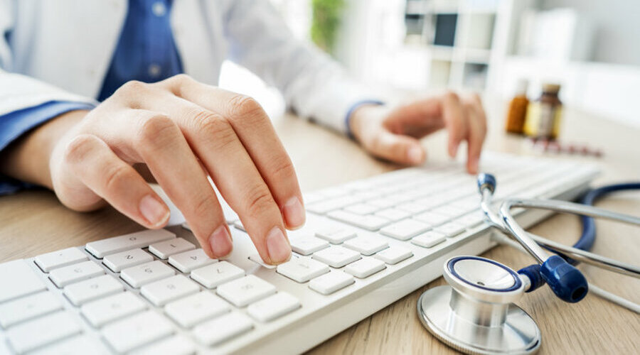 Female doctor typing on computer